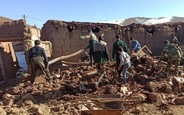 People dig through the debris of a collapsed building.