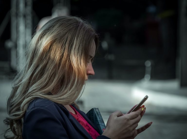 Woman checking text messages on her phone. Source : Pexels