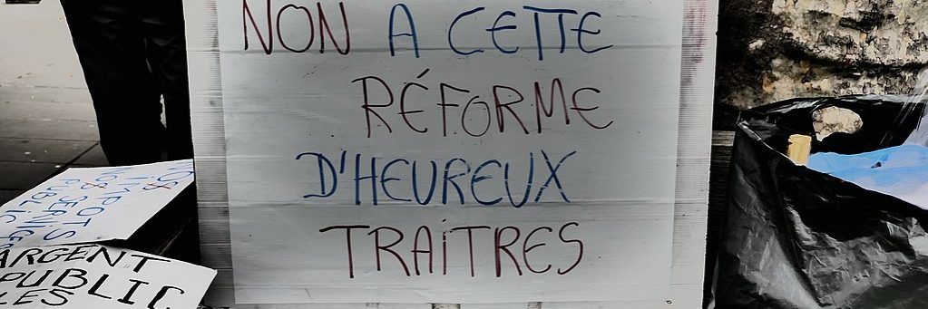 Protest sign reads "Non à cette réforme d'heureux traitres", literally "No to this reform of happy traitors"