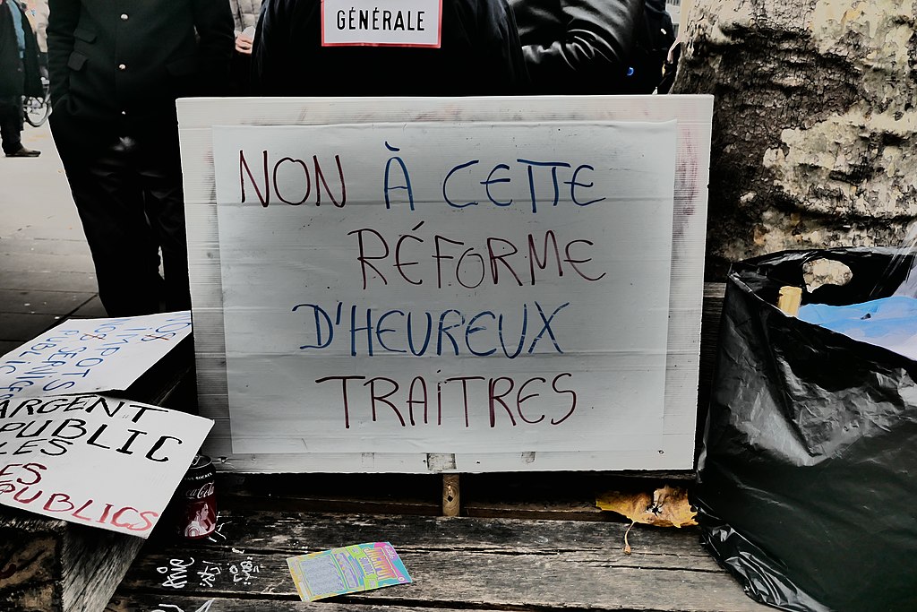 Protest sign reads "Non à cette réforme d'heureux traitres", literally "No to this reform of happy traitors"