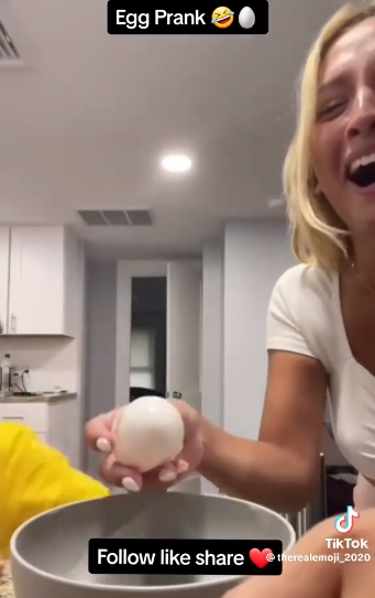 TikToker is seen laughing after cracking an egg on her son's forehead.