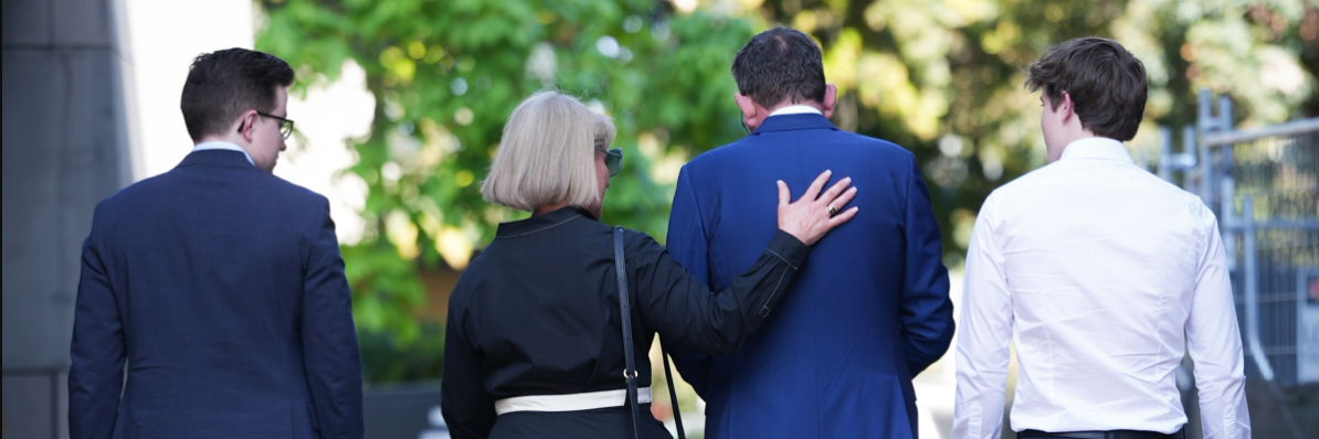 Dan Andrews and family walk away from parliament.