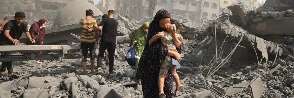 Palestinian woman carries child in Gaza Strip after Israeli retaliation for Hamas attacks