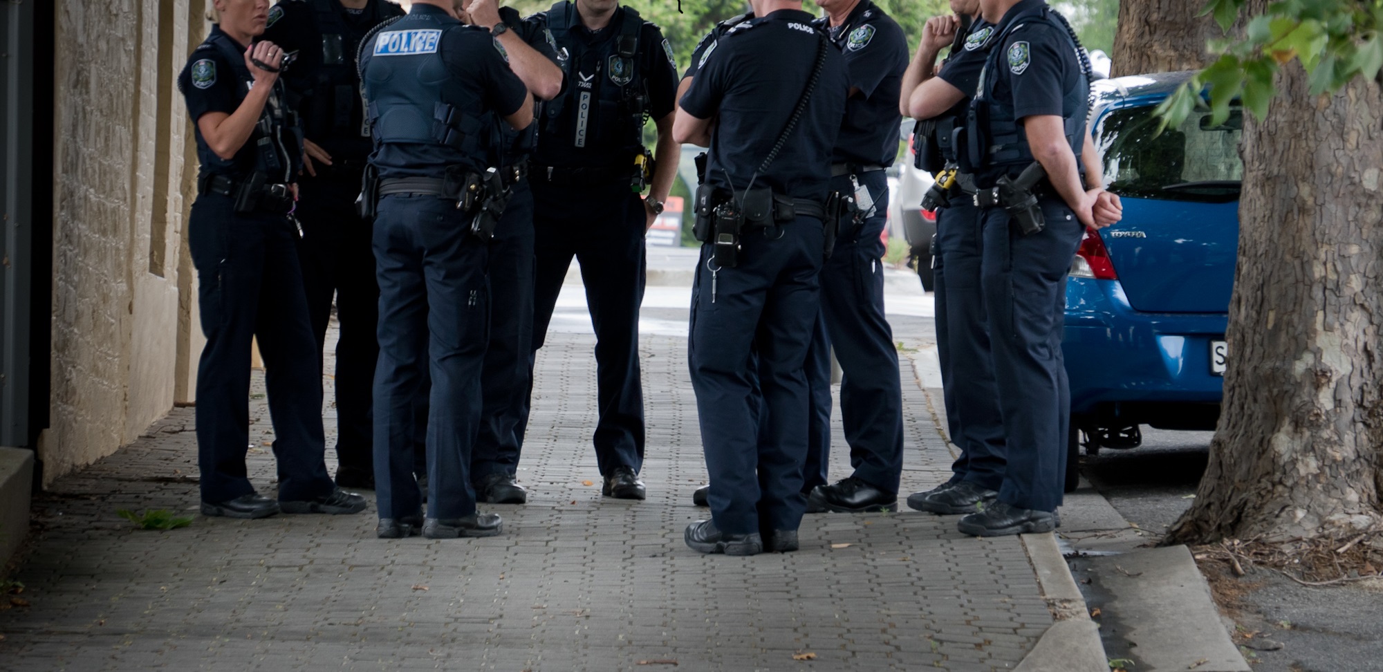 A group of police officers talking together on the footpath