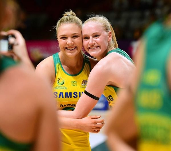 Netball players embrace on the court.