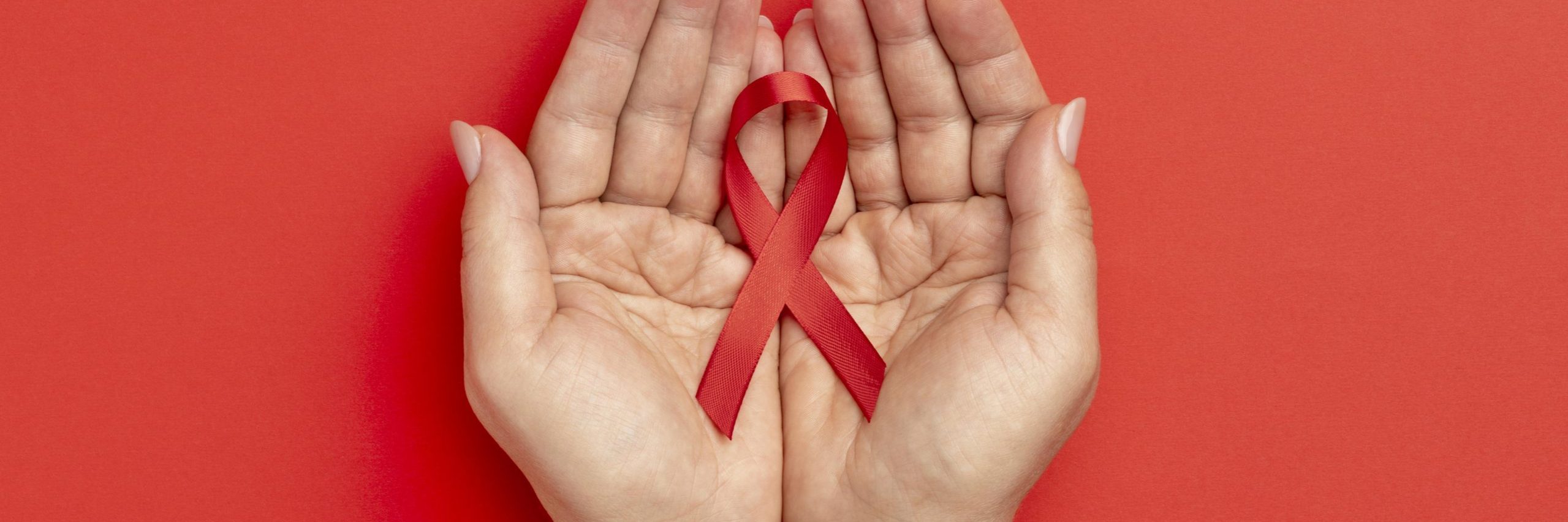 A person holding a red ribbon for World Aids Day