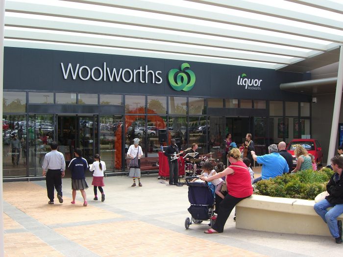 a crowd of people around entrance to Woolworths