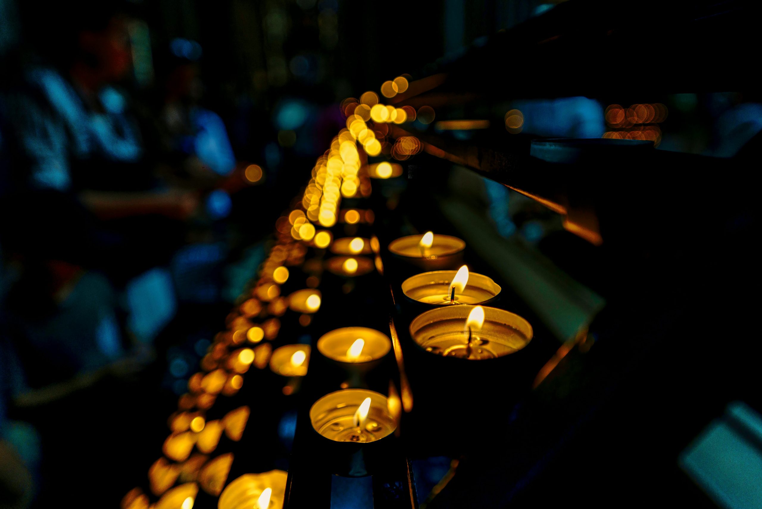 Rows of lit candles in a dark room. Vigil held for Jesse Baird and Luke Davies as police investigation is ongoing