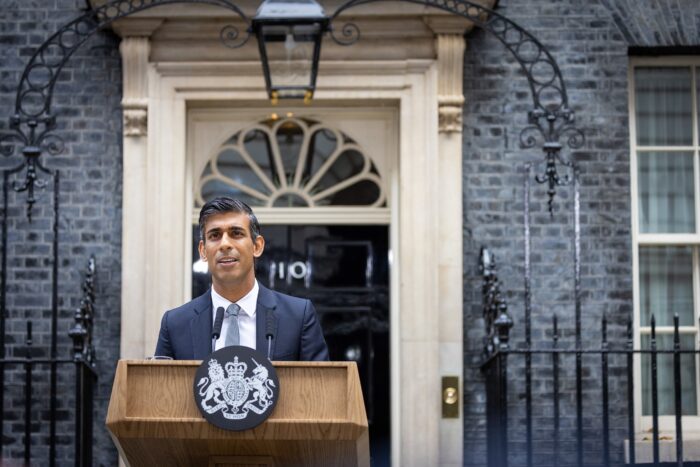 An image of British Prime Minister Rishi Sunak standing outside 10 Downing Street. He is currently handling allegations of improper gambling within his staff. Image source: Lauren Hurley, via: Wikimedia Commons