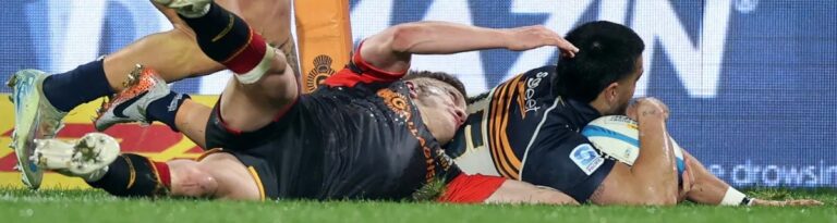 Chiefs playmaker Damien Mackenzie prevents Brumbies winger Tom Wright from scoring a try on Saturday. Photo: Super Rugby Pacific