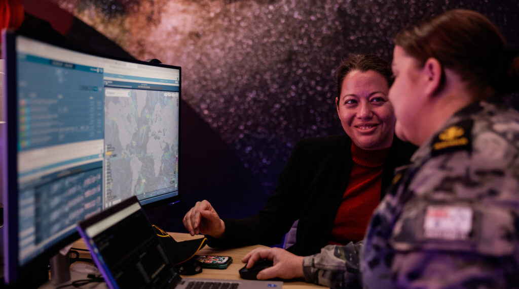 2023 … Barbara Golf, a strategic advisor with the US Space Force, carries out a system review with Leading Seaman Stacey Hooper in Adelaide. Photo: © Department of Defence