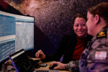 2023 … Barbara Golf, a strategic advisor with the US Space Force, carries out a system review with Leading Seaman Stacey Hooper in Adelaide. Photo: © Department of Defence