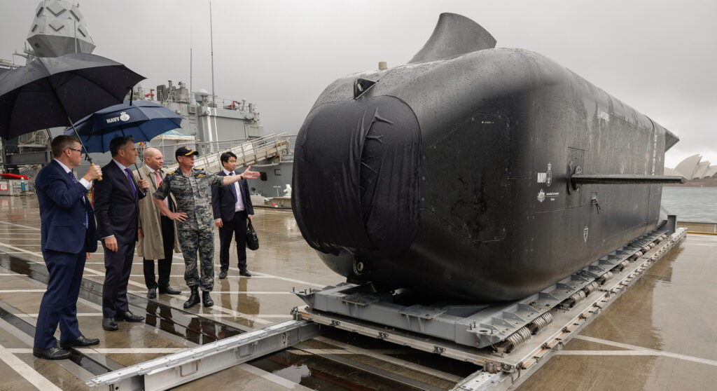Pat Conroy (far left) and Richard Marles with the new Anduril Aust Ghost Shark robot sub. Photo: Department of Defence