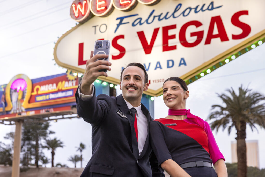 Qantas cabin crew celebrate the new service in front of an iconic sign. Photo: Qantas.