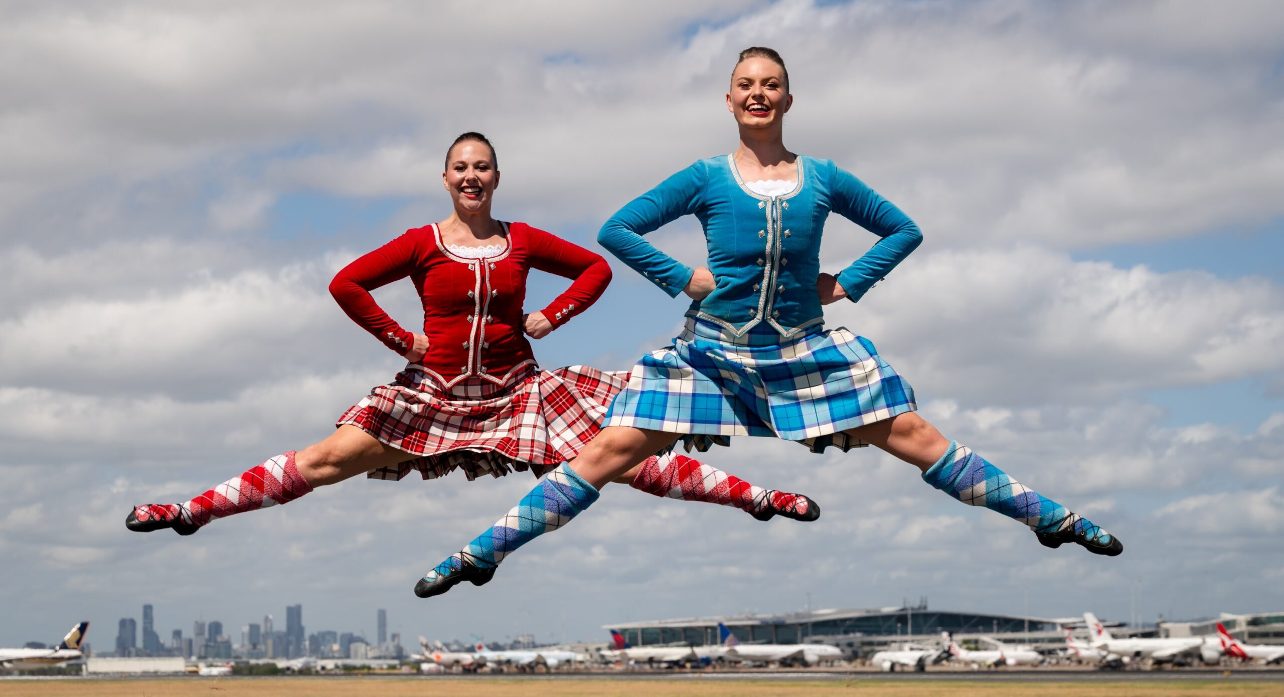 Highland dancers Sian Roach and Macey Bennett on the tarmac at Brisbane airport. Photo: Sarah Marshall.
