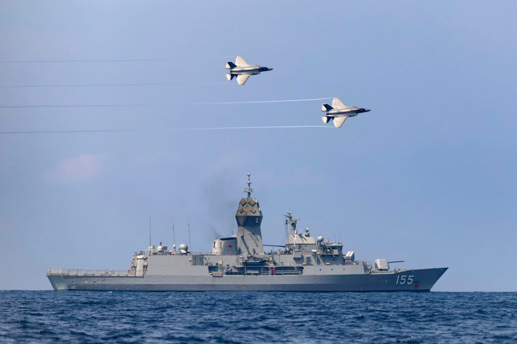 RAAF F-35 jets fly over the HMAS Ballarat off the coast of Malaysia last year as part of Exercise Bersama Lima 25. Photo: Department of Defence.