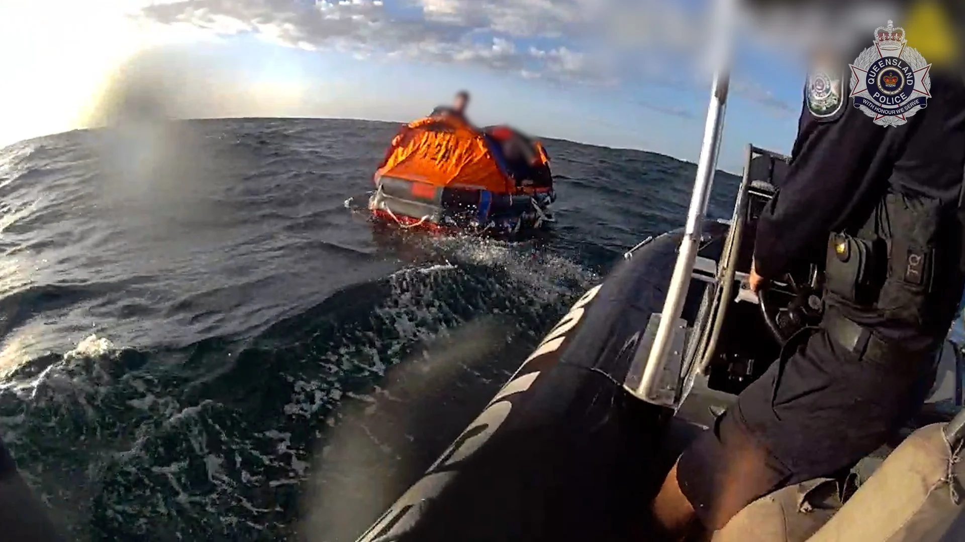 The divers are rescued from the raft that was dropped to them. Photo: Qld Police.