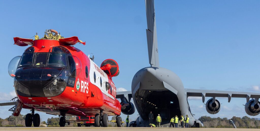 more ... A NSW RFS Chinook heavy-lift water tanker is loaded onto a C-17A Globemaster at RAAF Base Richmond, Sydney. The aircraft left for France on the same day. It is equipped with night vision for 24-hour operations. Photo Department of Defence