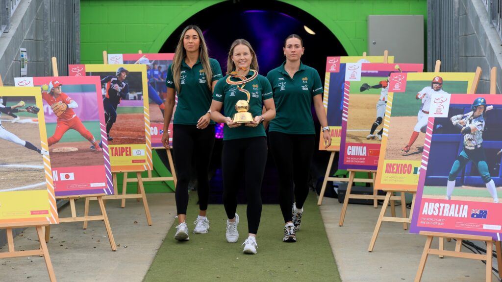 Tickets … The 2027 World Cup trophy is revealed by (from Left) Kylie Steemers, Tamieka Whitefield Jenna Trim at Redcliffe Stadium, Brisbane. Photos: SOFTBALL AUSTRALIA