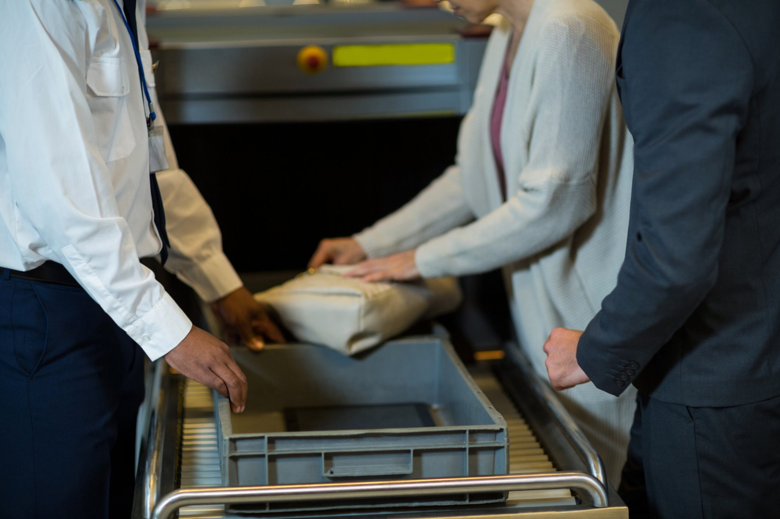 Adelaide Airport biosecurity: staff and a traveller at a baggage screening machine