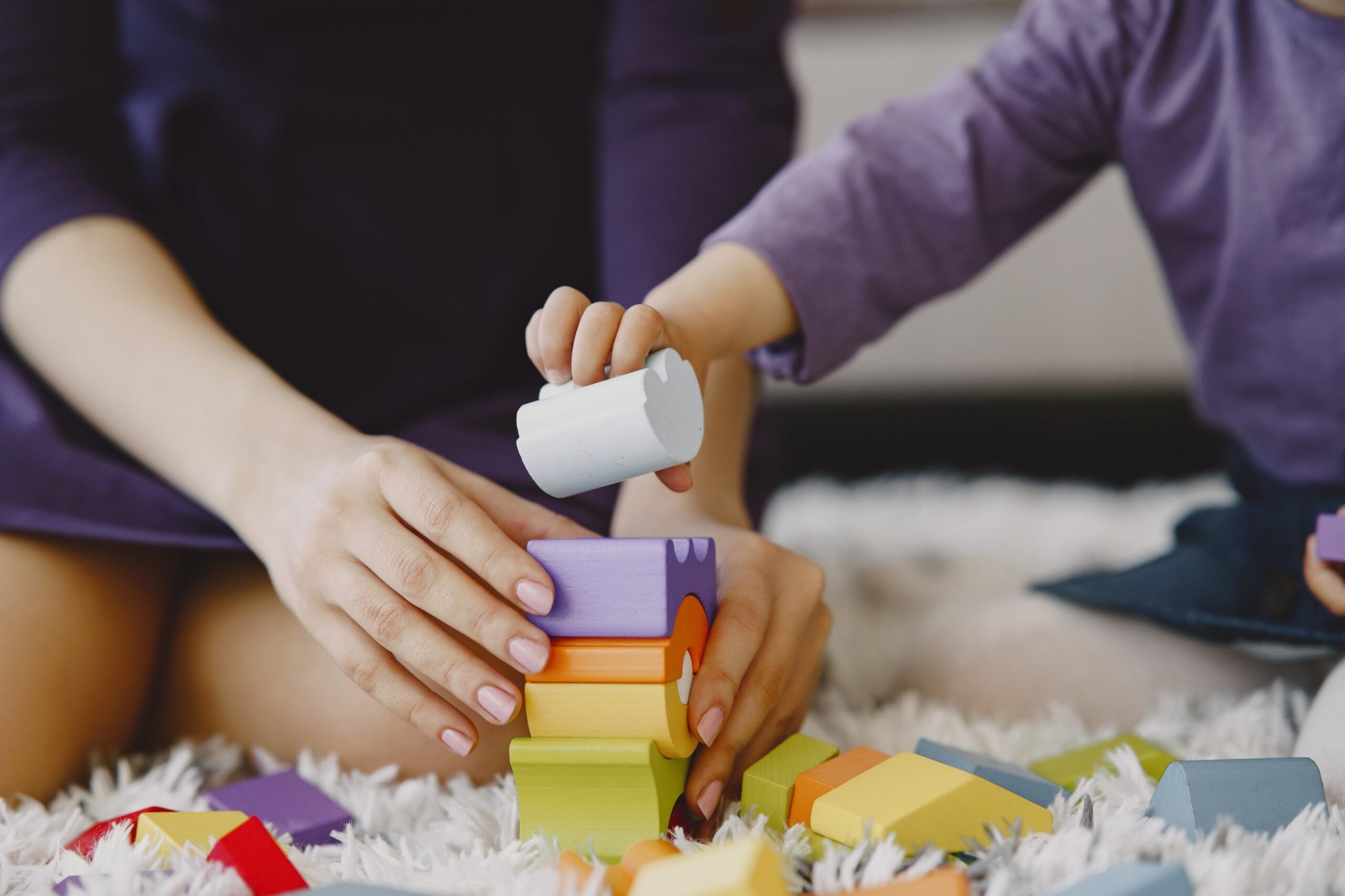 Parent and child stacking wooden blocks, worker retention payment