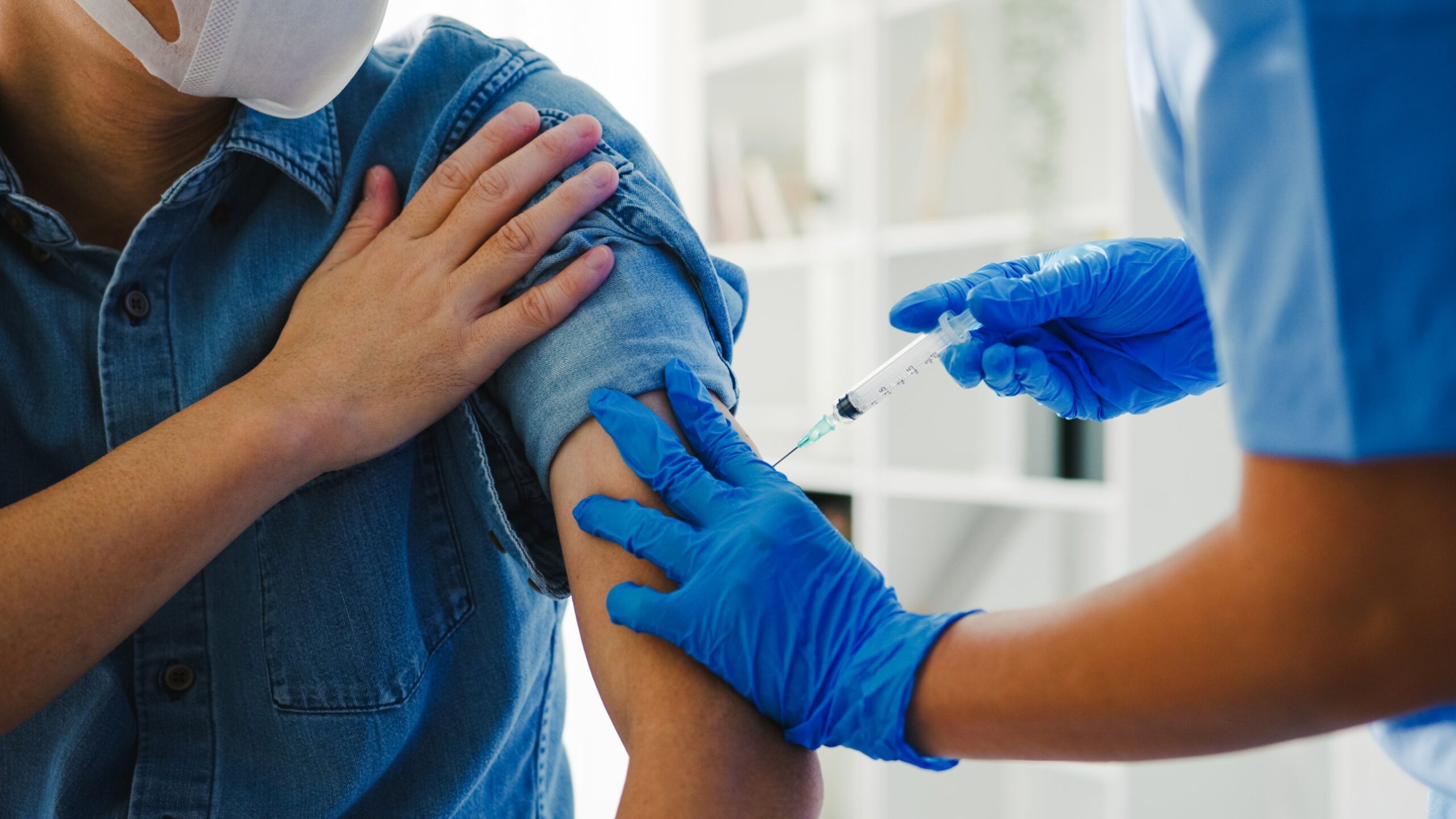 Nurse giving a free COVID-19 vaccine to a patient in a clinic