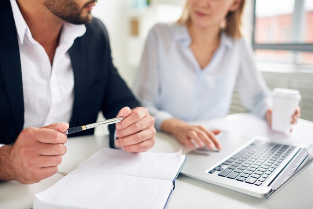 Two people reviewing paperwork at a desk, NDIS plan management panel