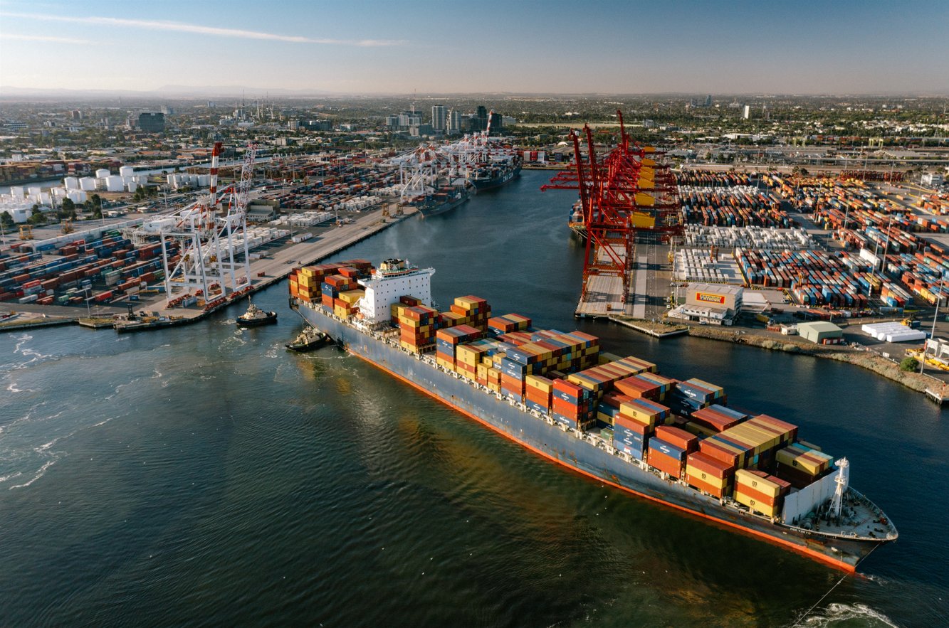 Aerial view of a container ship and tugs at the Port of Melbourne, a biosecurity entry point