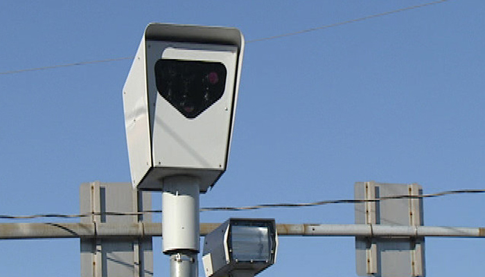 Red-light speed camera mounted on a pole above an intersection