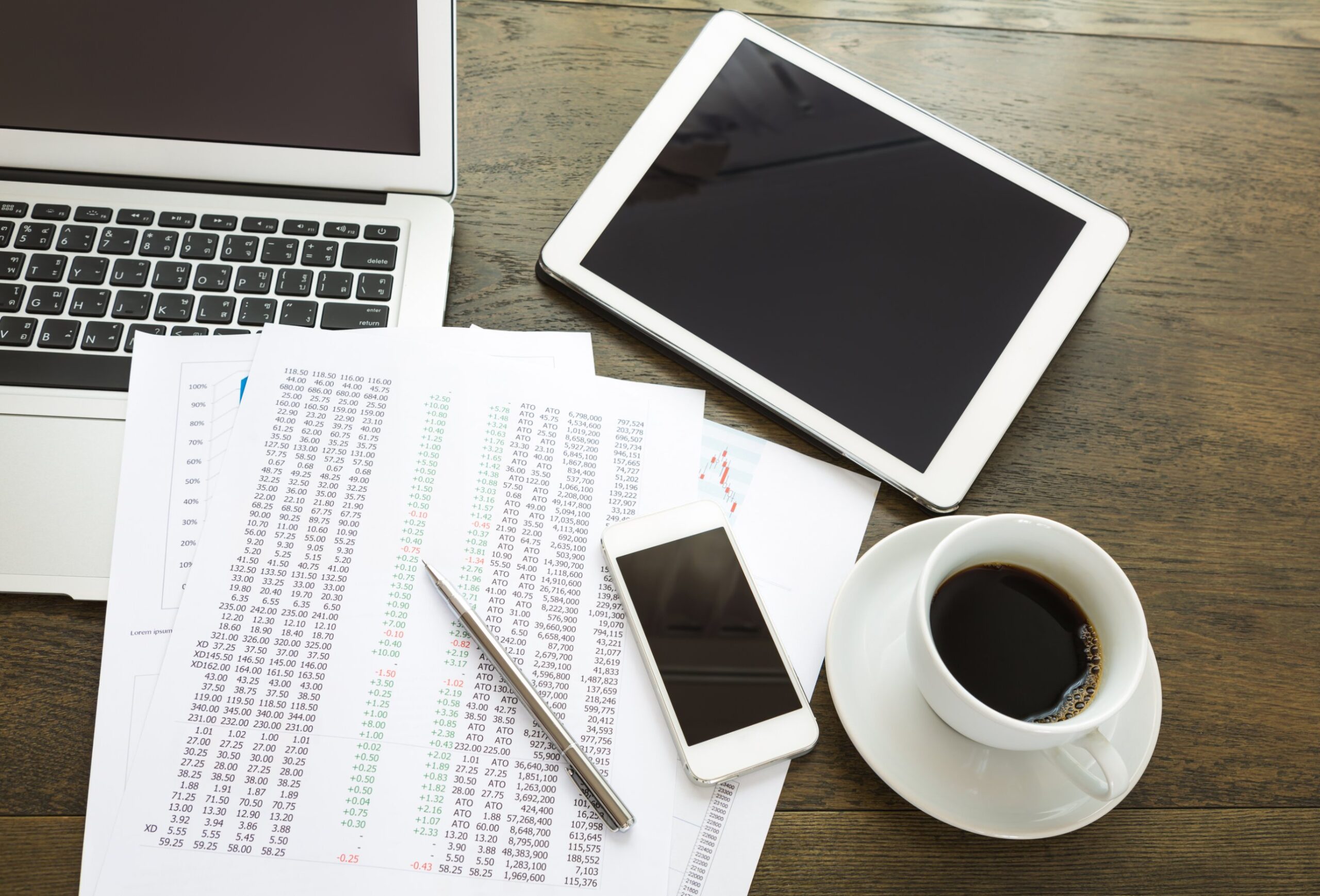 Desk with printed financial figures, a tablet, a phone and a cup of coffee, illustrating the CCS Creditors Trust dividend notice